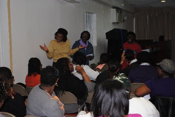 A group of people sitting in chairs listening to a speaker