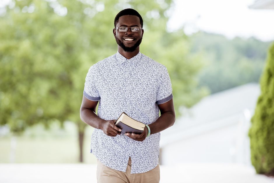 Eastchester Church of God. man is holding a bible in his hands and smiling.