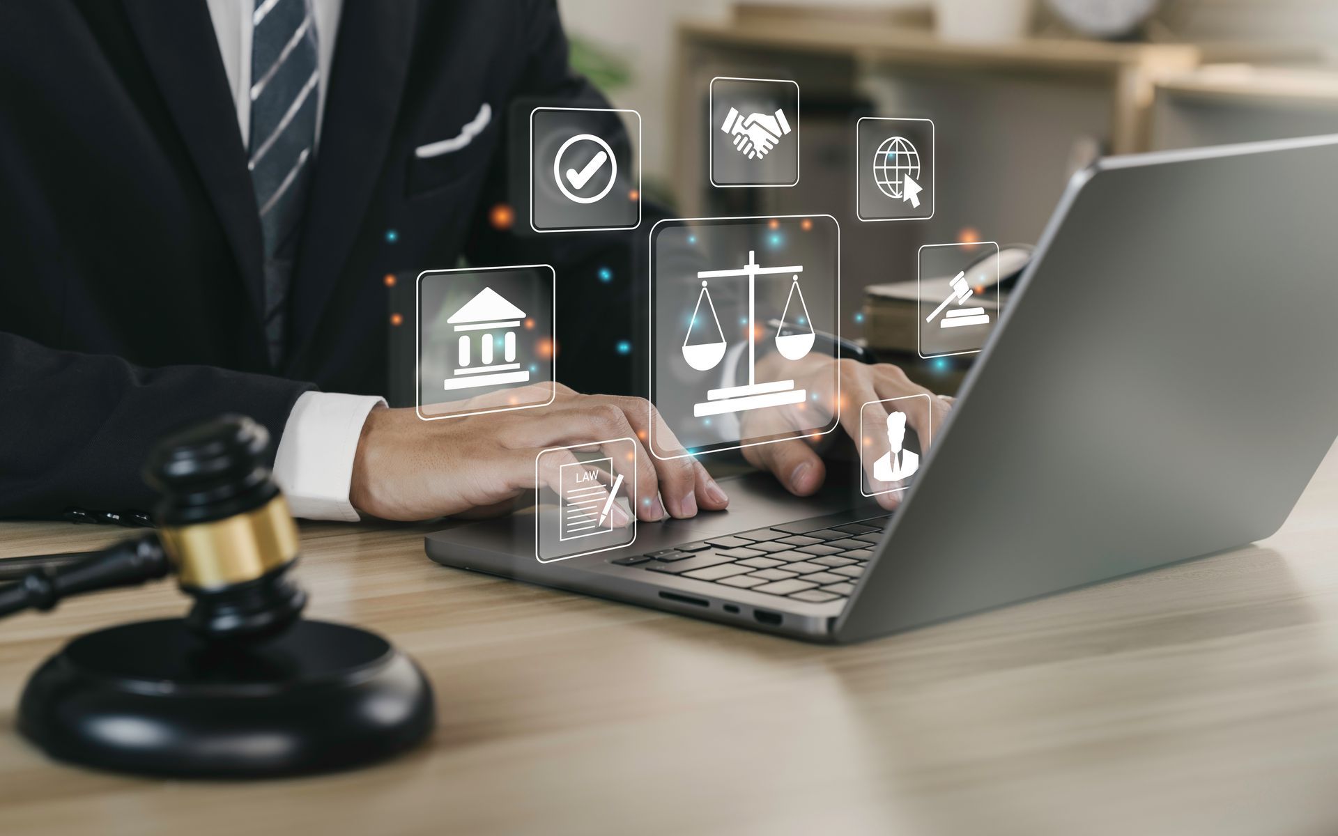 Person, die auf einem Laptop mit digitalen Rechtssymbolen und Hammer tippt.