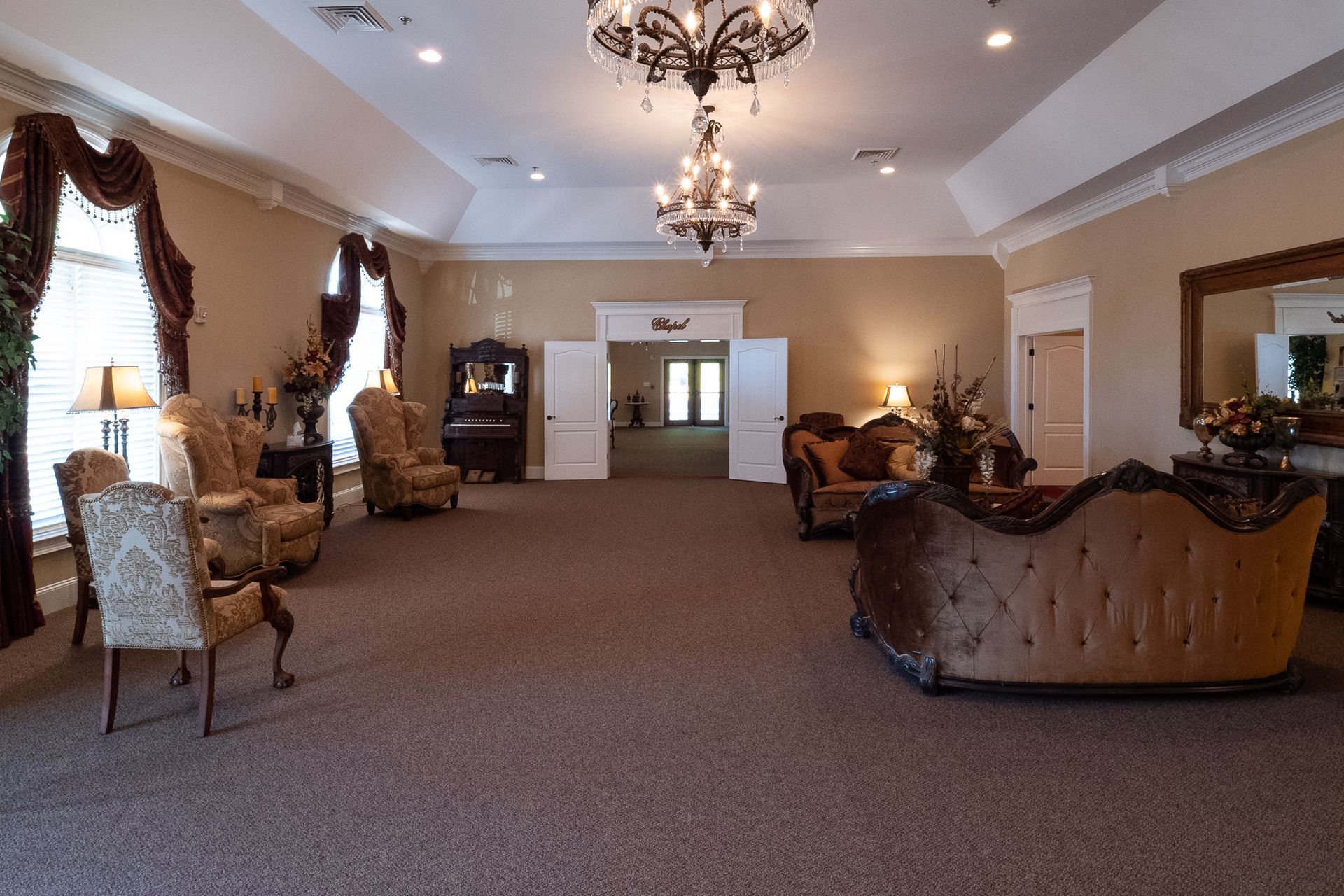 Elegant hotel lobby with chandeliers, tufted sofas, and carpeted seating area