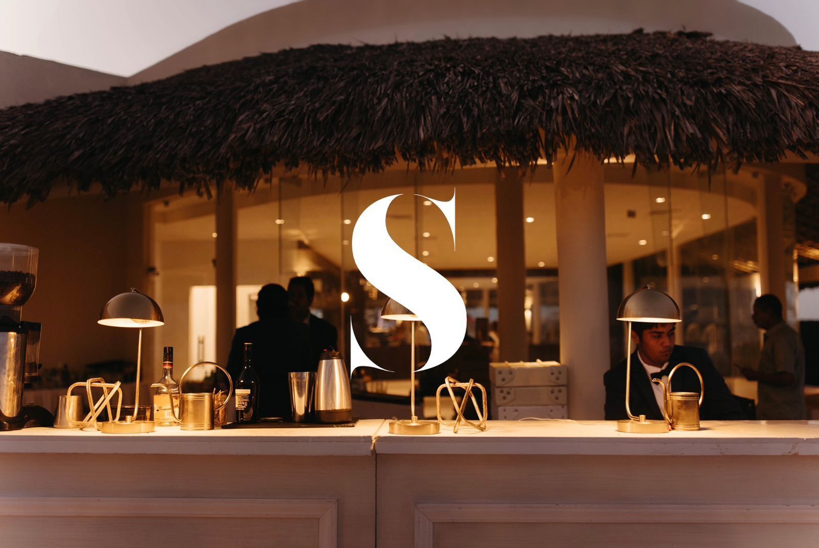 A restaurant with a thatched roof and a sign that says ' s ' on it