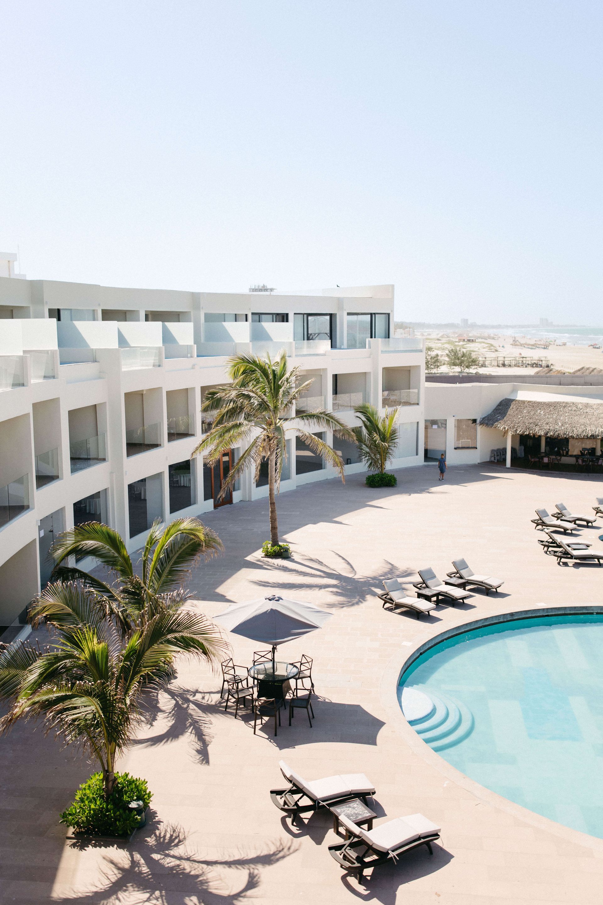 An aerial view of a hotel with a large swimming pool