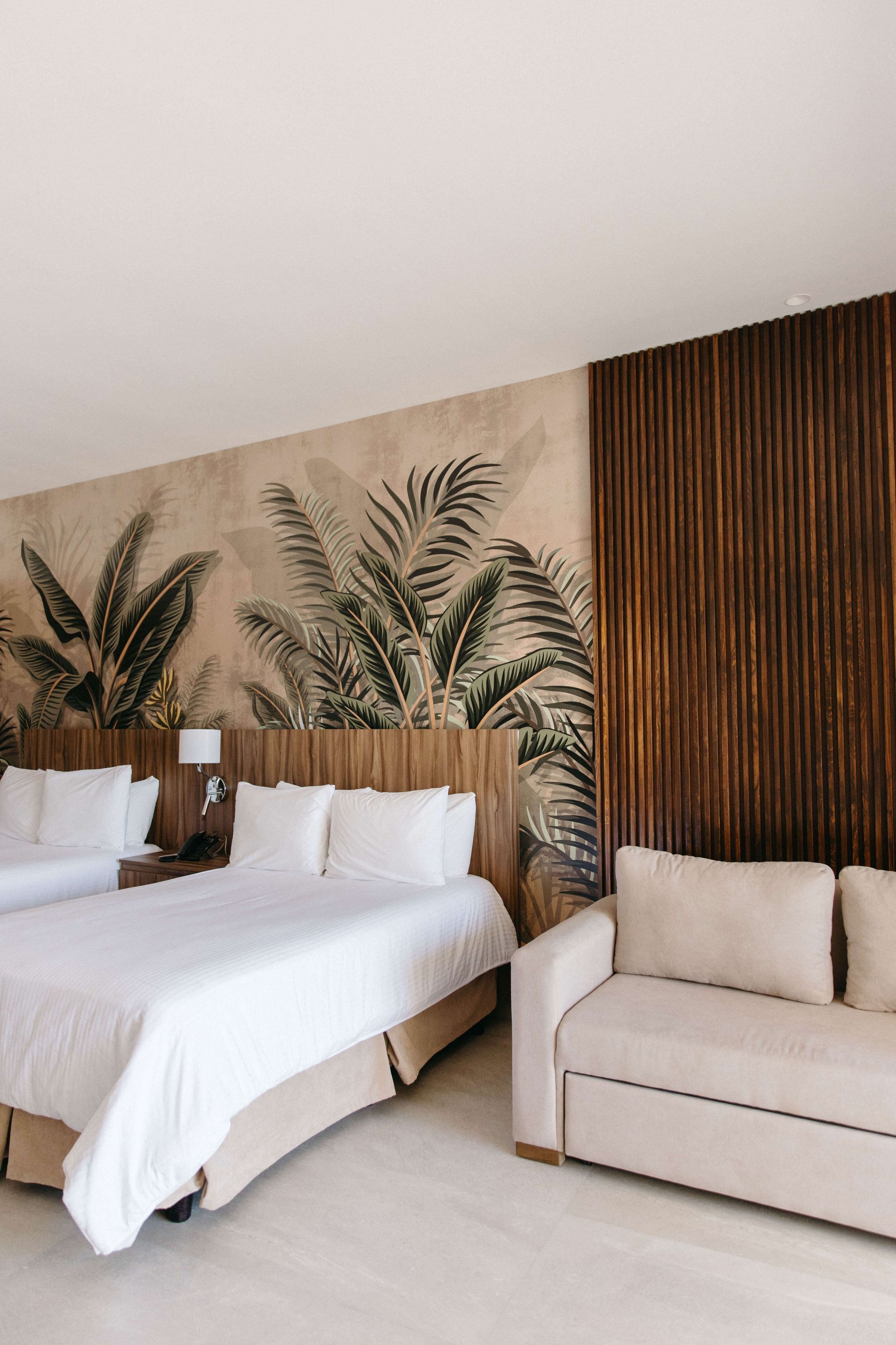 A hotel room with two beds and a couch.