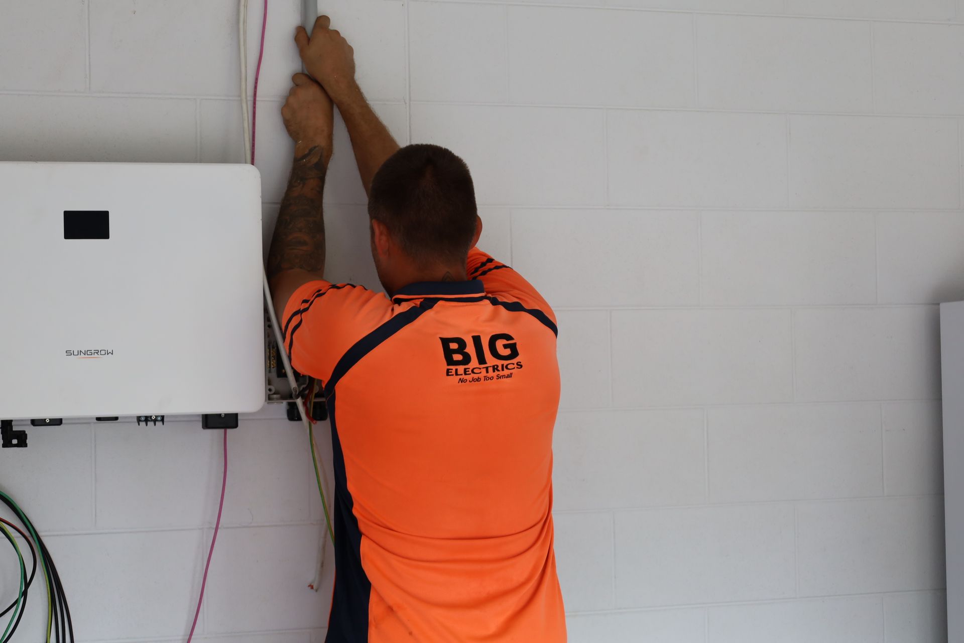 Person Holds Orange Multimeter — Big Electrics in Redlynch, QLD