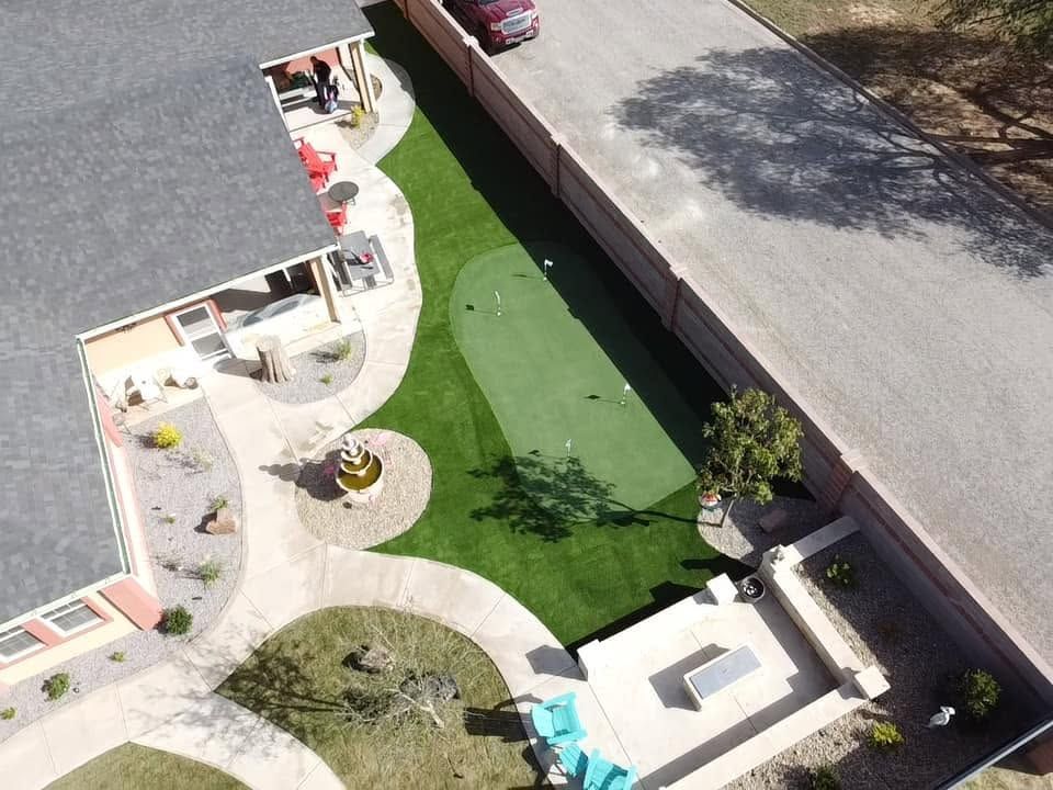 Backyard pool with patio chairs, small cabana, and a lake view beyond the fence