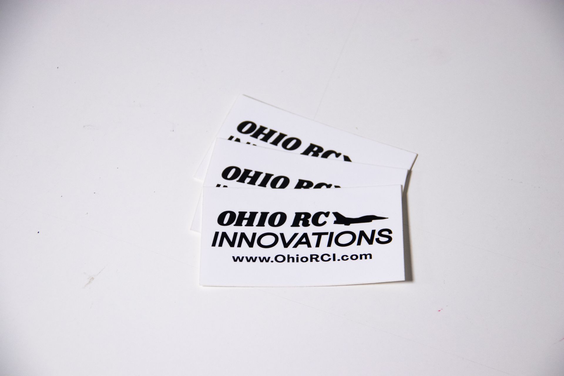 Stack of white Ohio RC Innovations business cards on a light surface