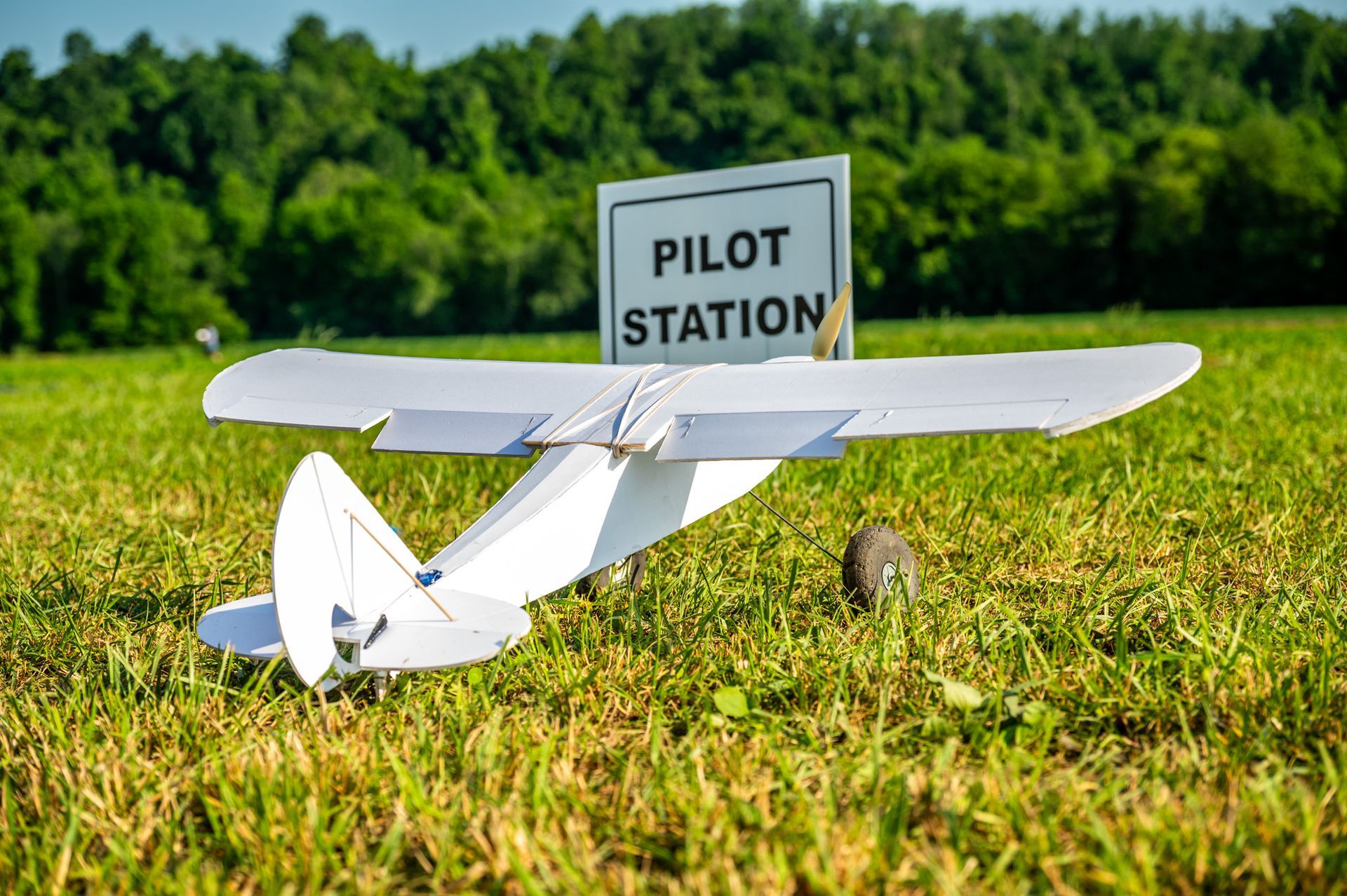 Small yellow biplane flying against a clear blue sky