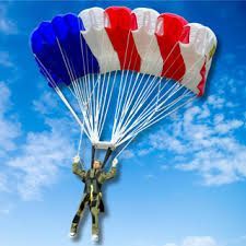 Skydiver descending under a red, white, and blue parachute against a blue sky