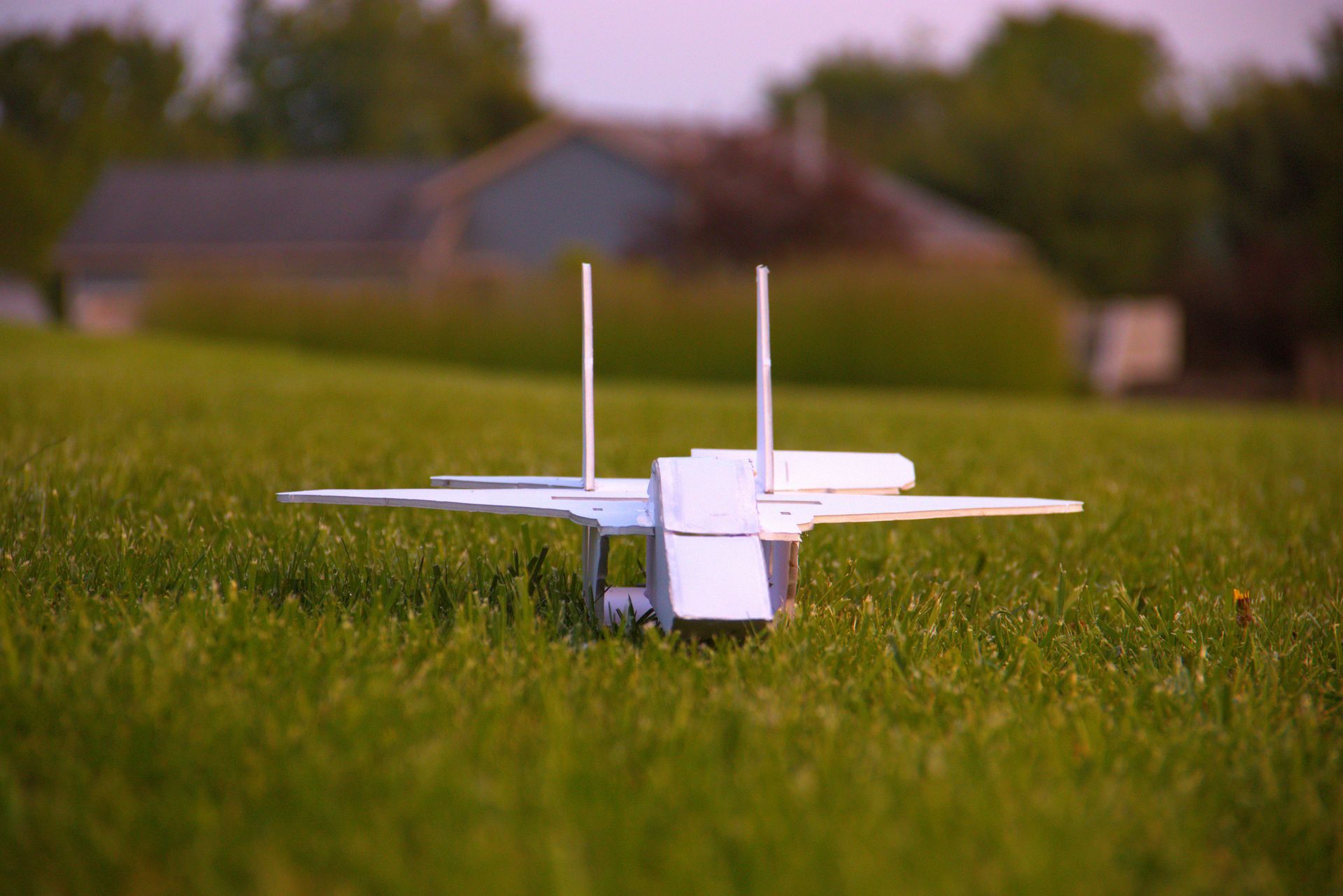 White model jet plane resting on green grass outdoors