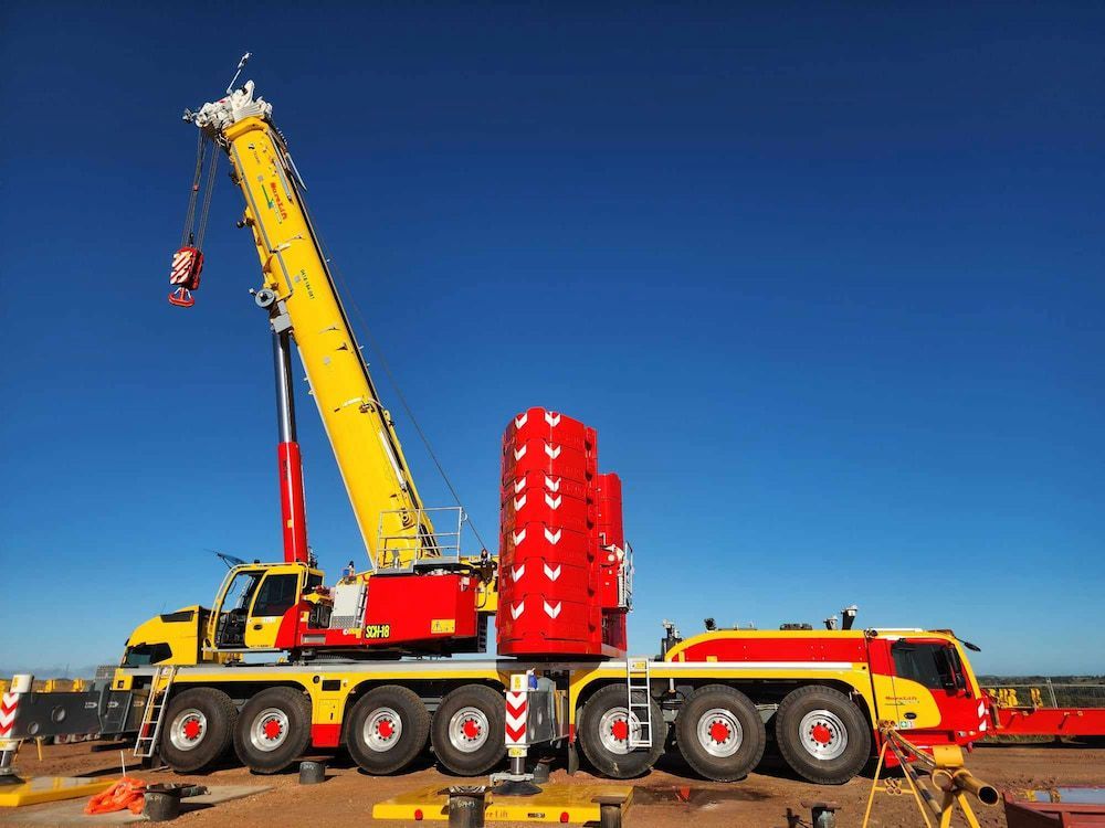 A Large Yellow And Red Crane Is Sitting On Top Of A Truck — SureLift Crane Hire In Collinsville, QLD