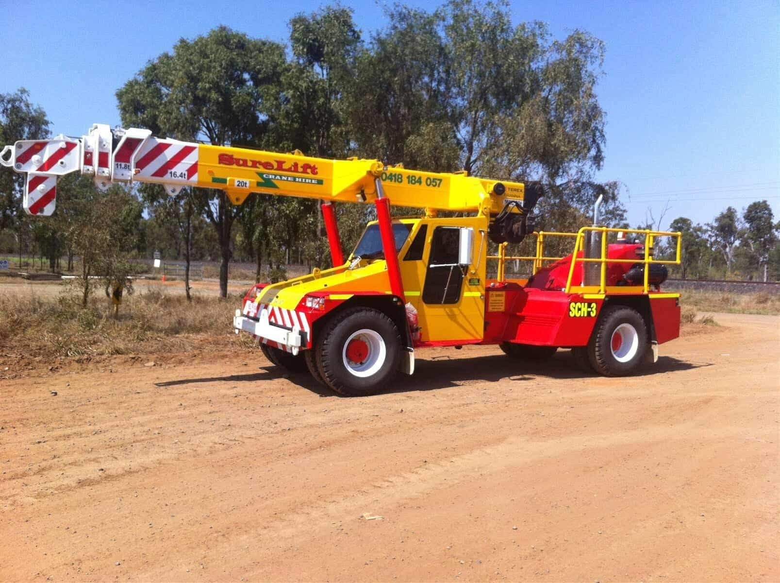 A Yellow And Red Truck With A Crane On The Back — Surelift Crane Hire In Bowen, QLD