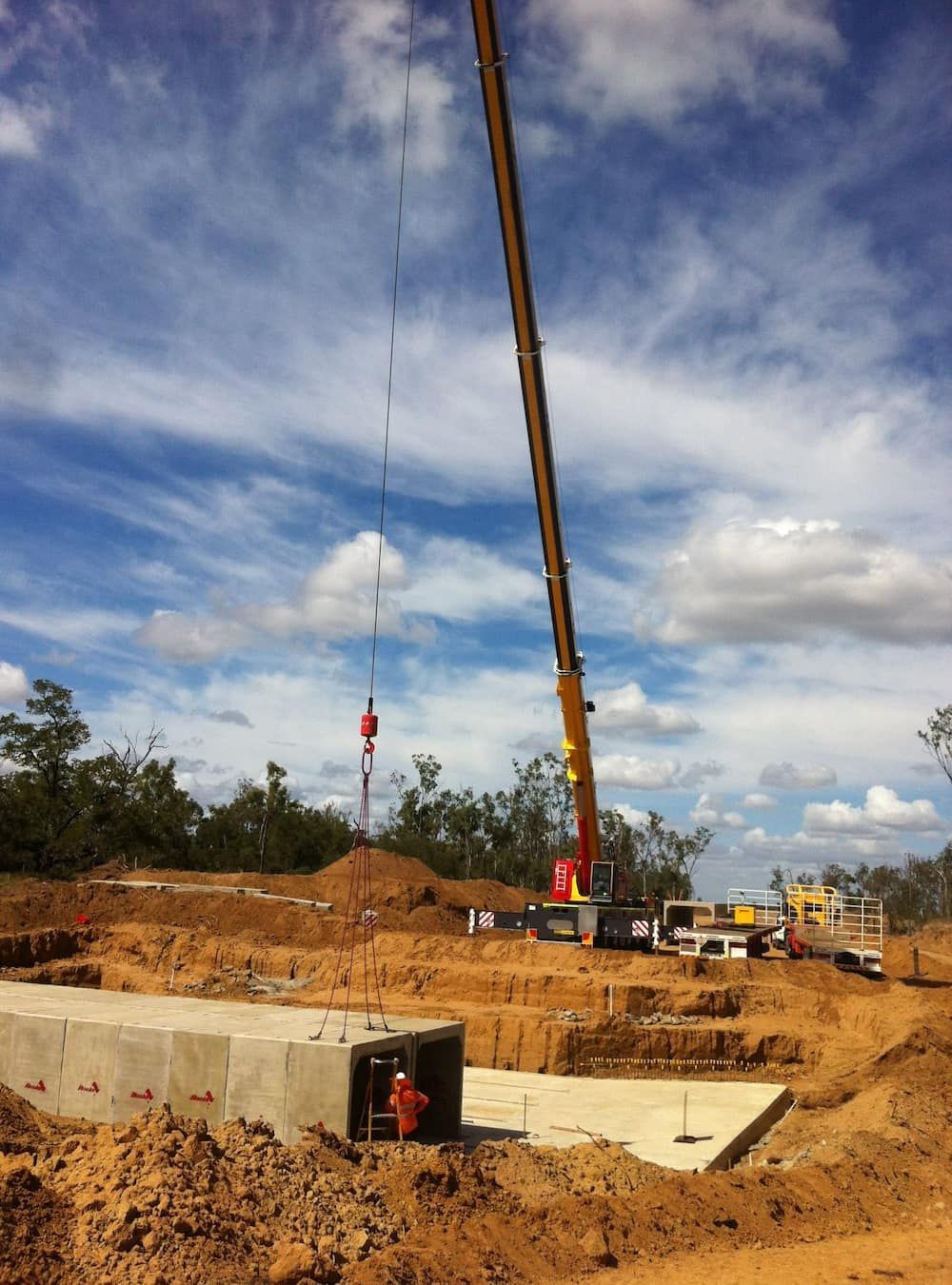 A Construction Site With A Crane Lifting A Concrete Block — SureLift Crane Hire In Emerald, QLD