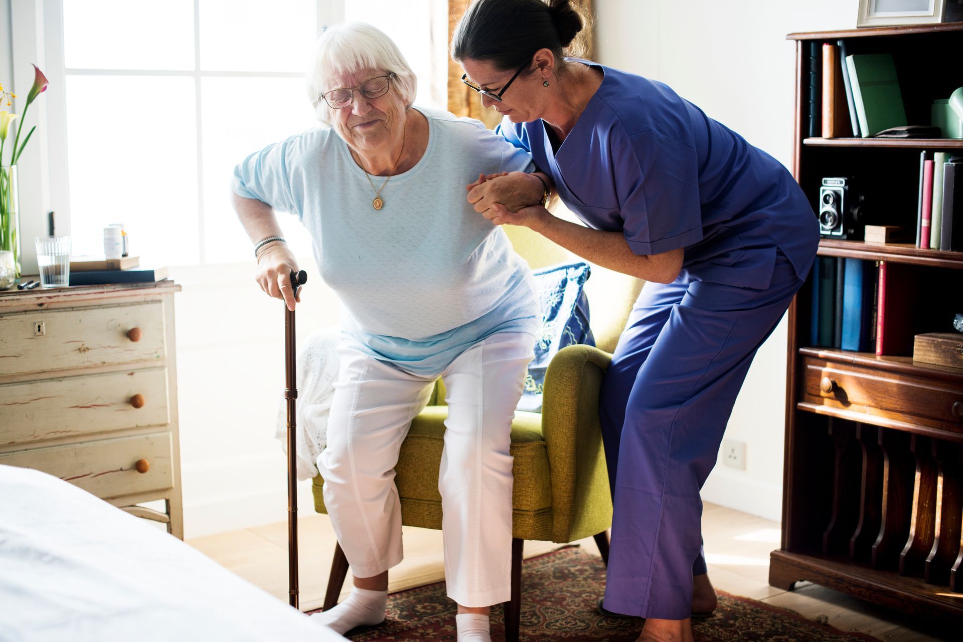 Woman in wheelchair smiles at caregiver in a sunny outdoor setting Woman in wheelchair smiles at caregiver in a sunny outdoor setting