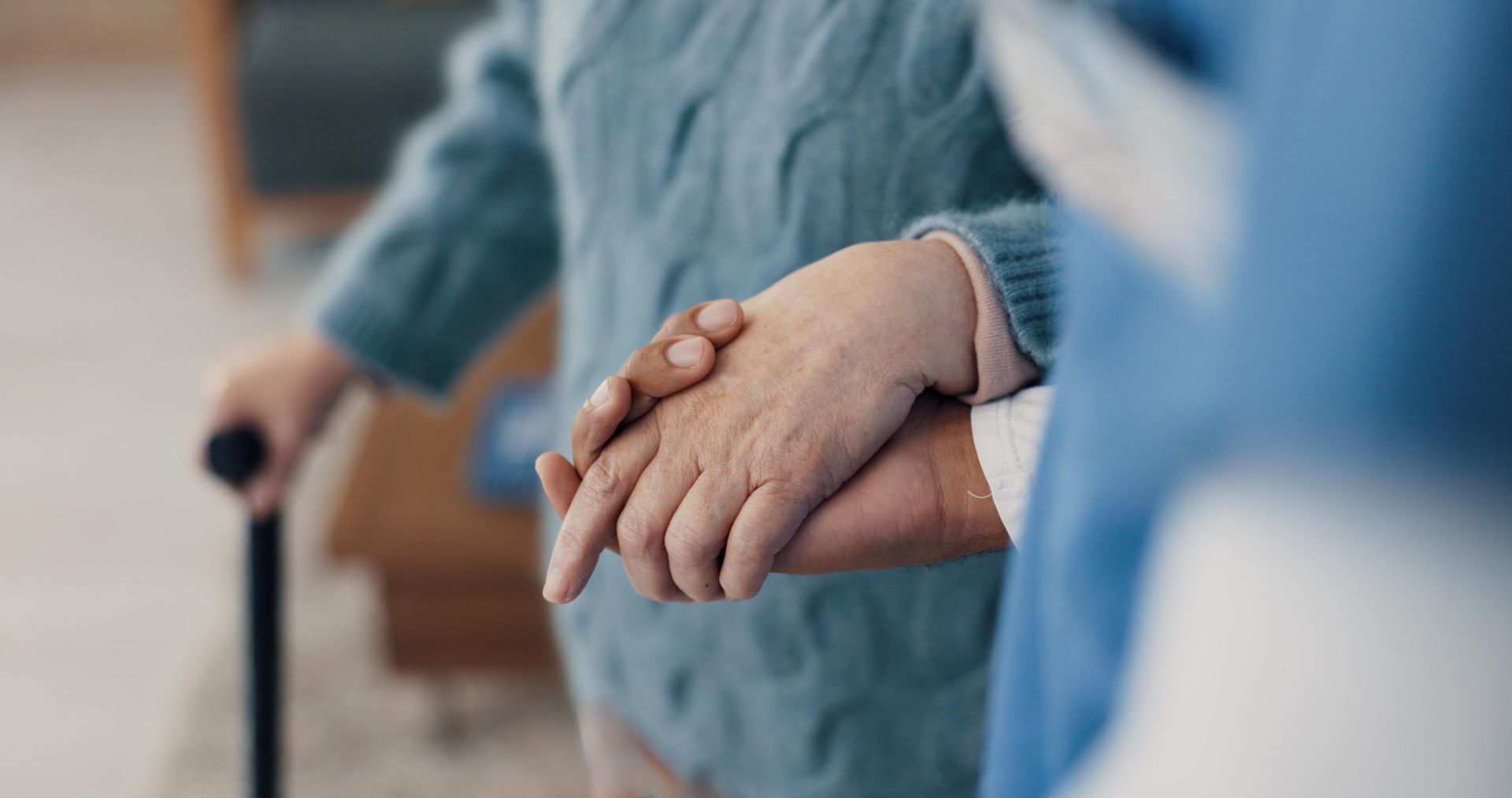 Person holding the hand of another, with cane, possibly assisting them Person holding the hand of another, with cane, possibly assisting them