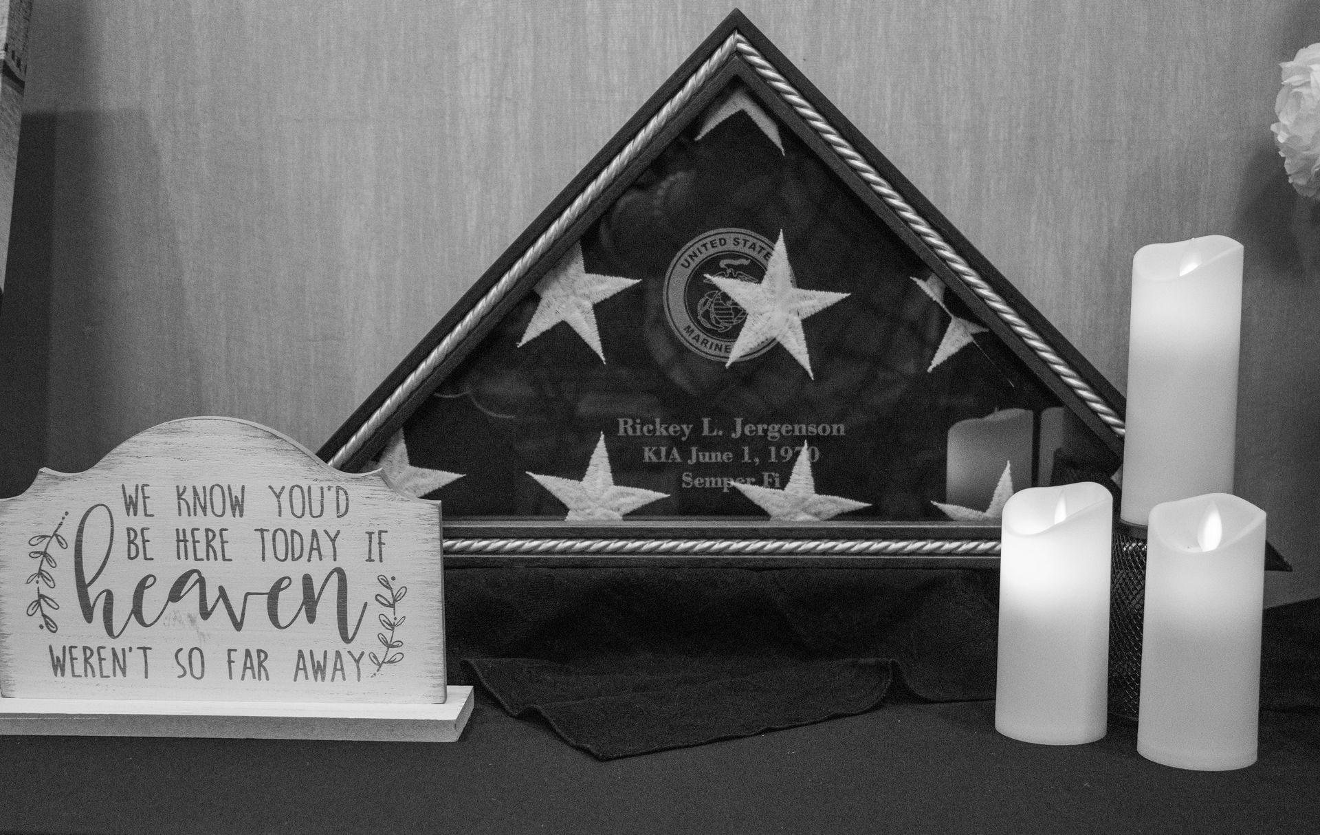 A memorial display with a folded American flag in a case, a sign reading 