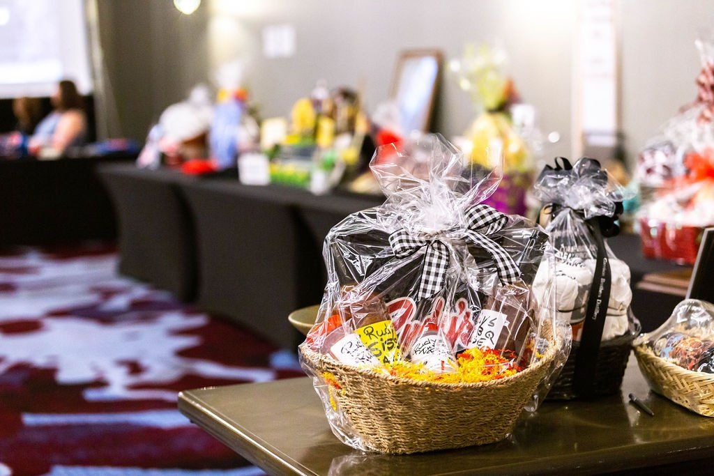Gift baskets arranged on tables at a silent auction event.
