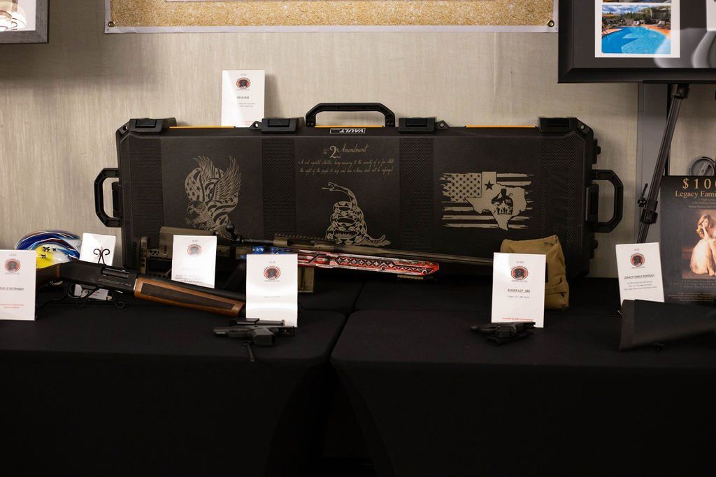 A black gun case with tactical engravings displayed on a black table with small white informational cards.