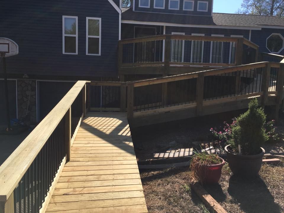 Wooden ramp leading to a deck on a blue house.
