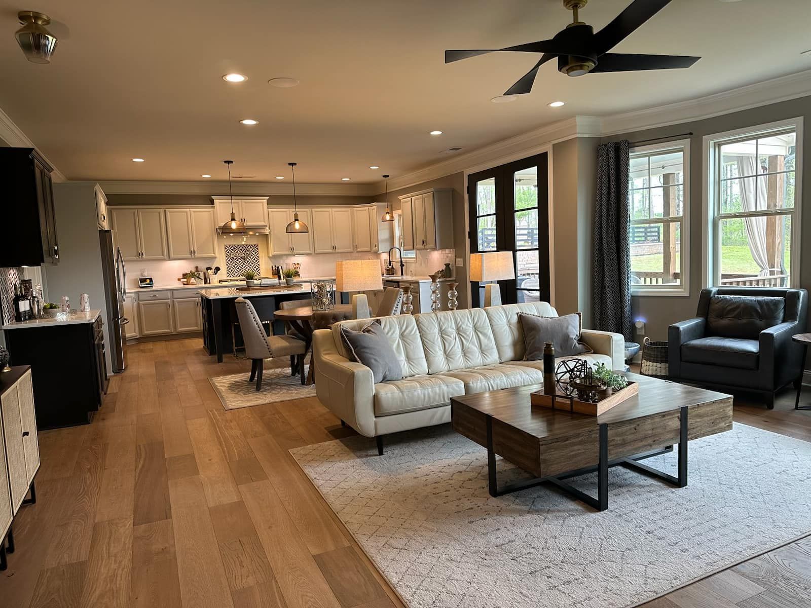 Open-concept living space with kitchen, living room, and dining area. Neutral colors, hardwood floors, and a modern design.