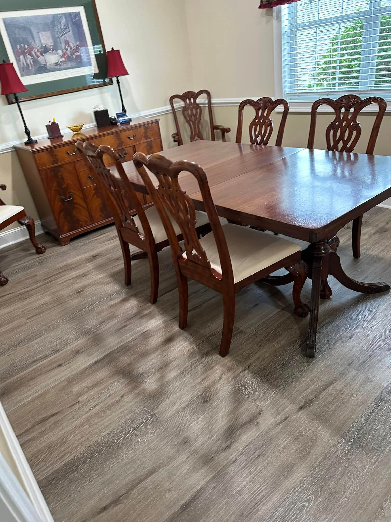 Dining room with a wooden table, chairs, and a buffet.