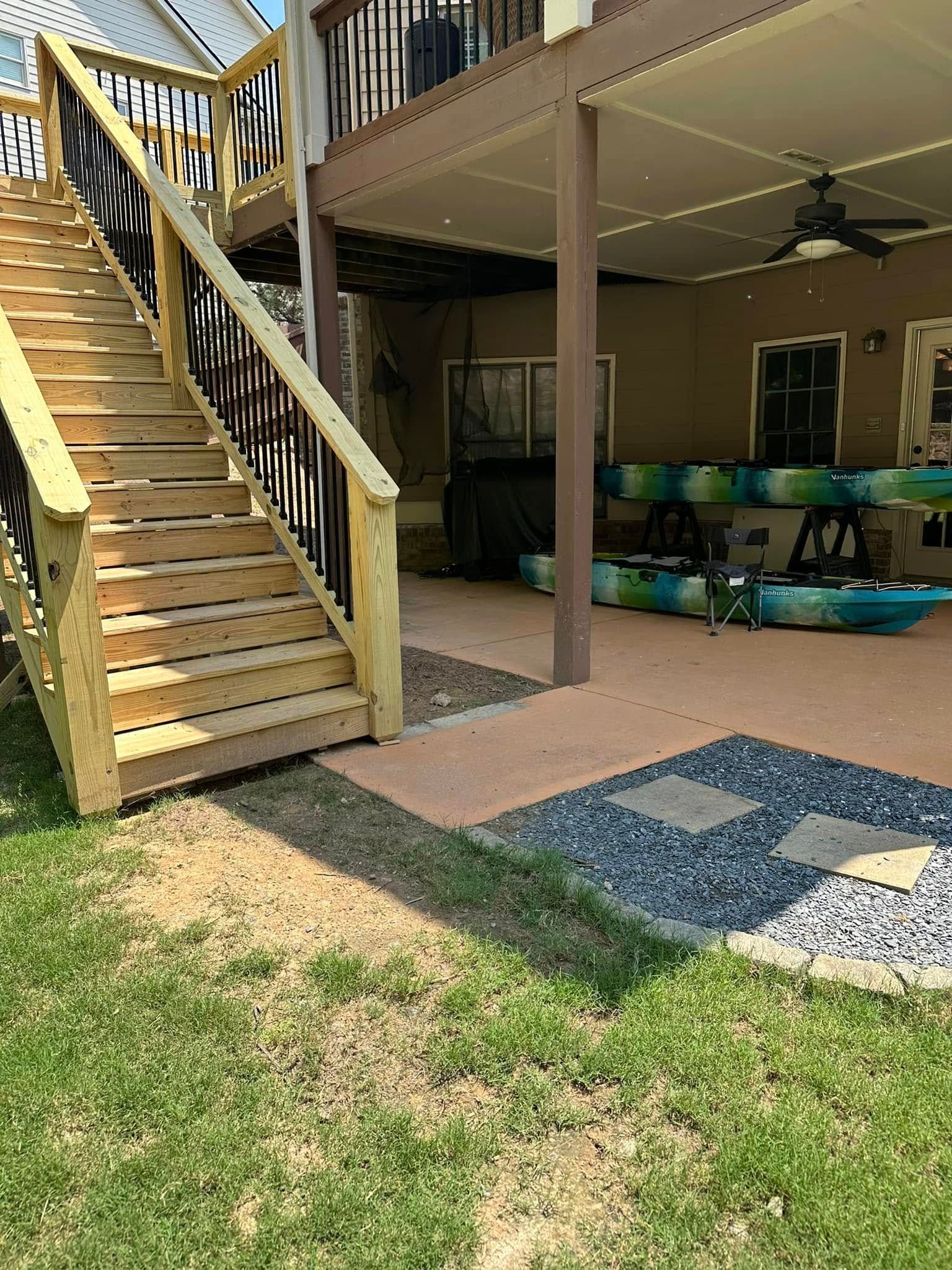 Wooden deck stairs lead up to a covered patio with kayaks stored below.