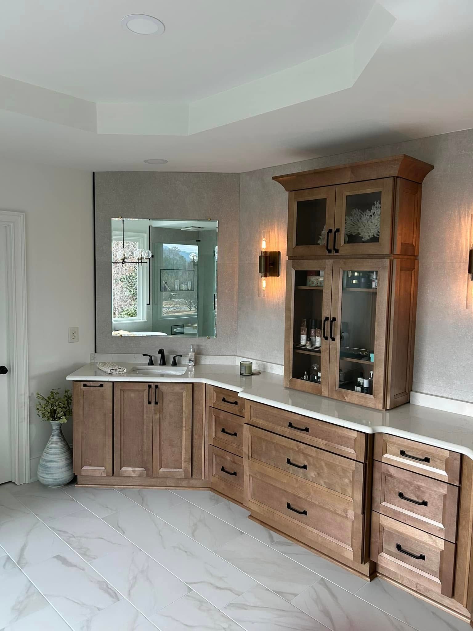 Bathroom with light wood cabinets, white countertops, and a large mirror.