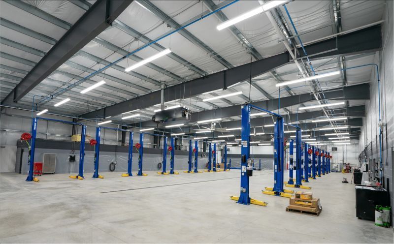 A large warehouse with a lot of lifts in it.
