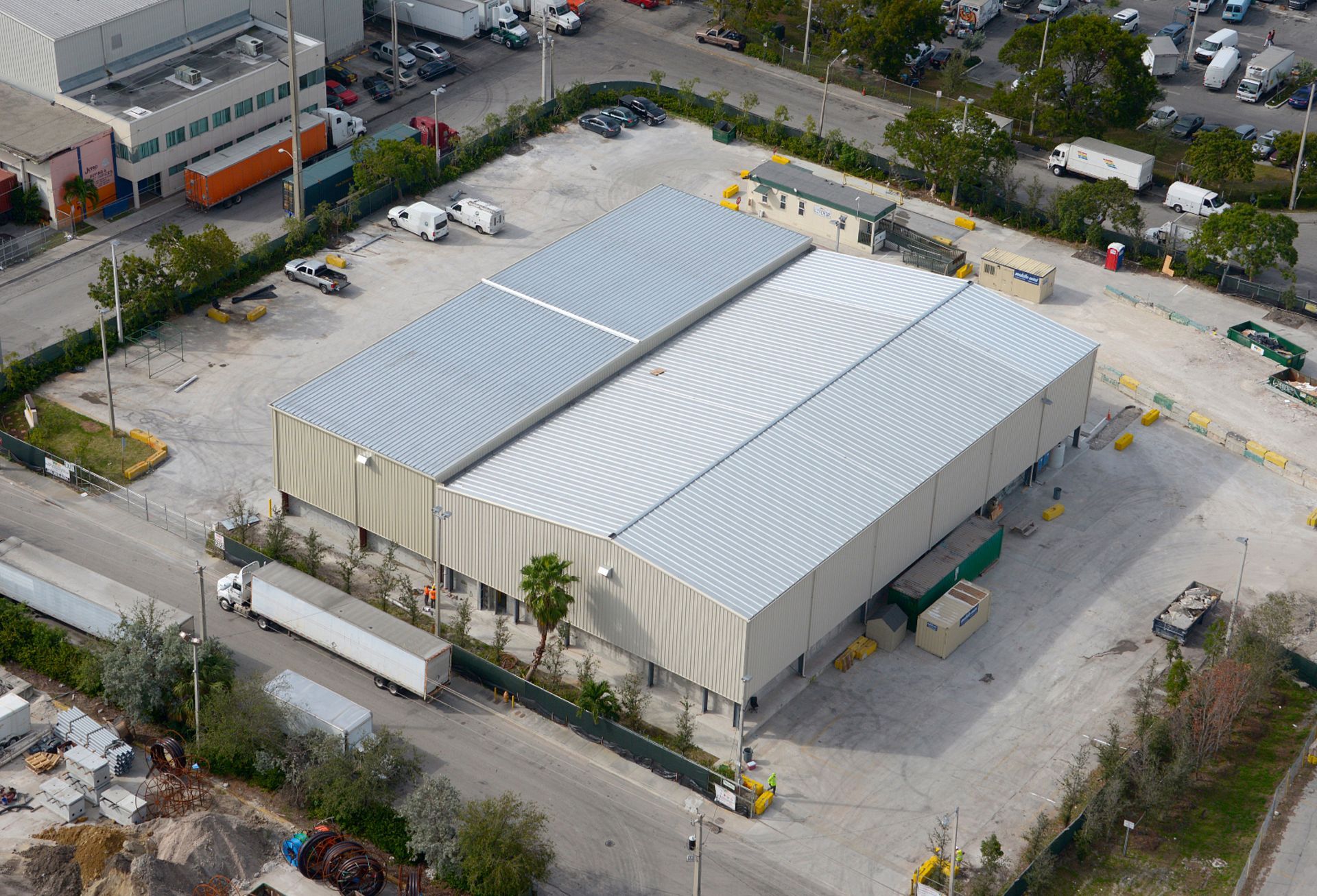 An aerial view of a large warehouse with trucks parked in front of it