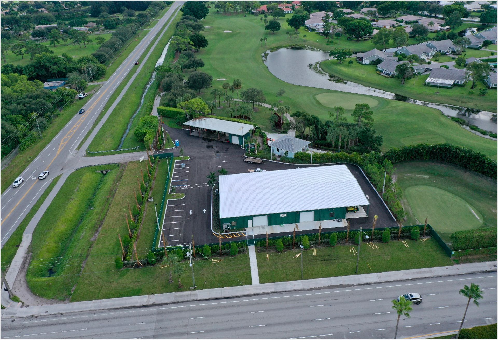 An aerial view of a golf course with a building in the foreground