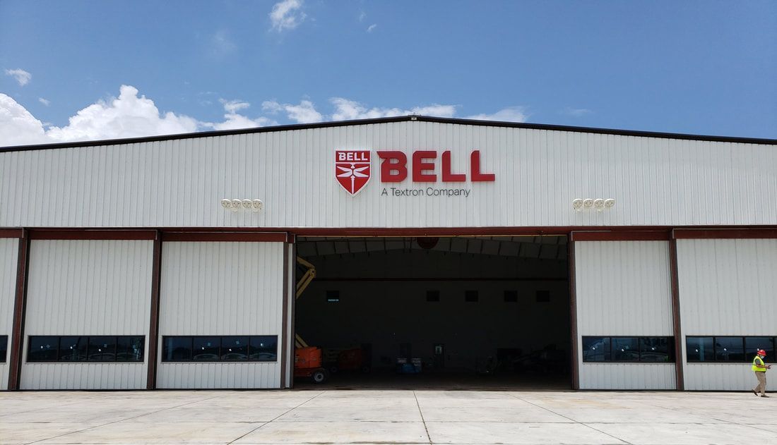 A large white building with a red bell logo on it.