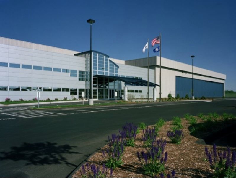 An airplane is parked in a hangar with the doors open
