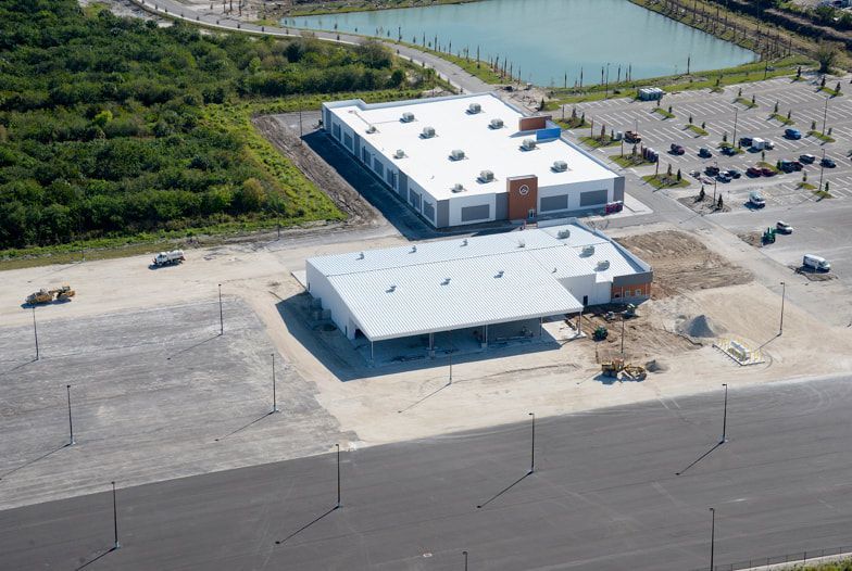 An aerial view of a building under construction with a white roof