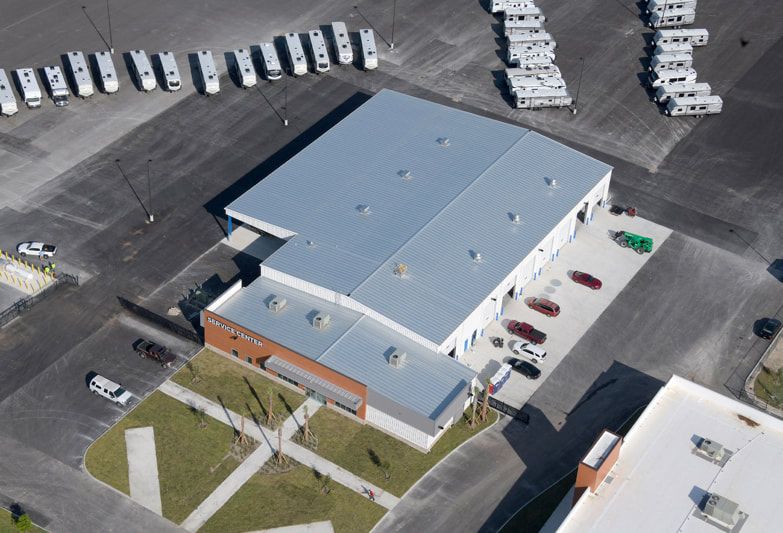 An aerial view of a building with a lot of cars parked in front of it