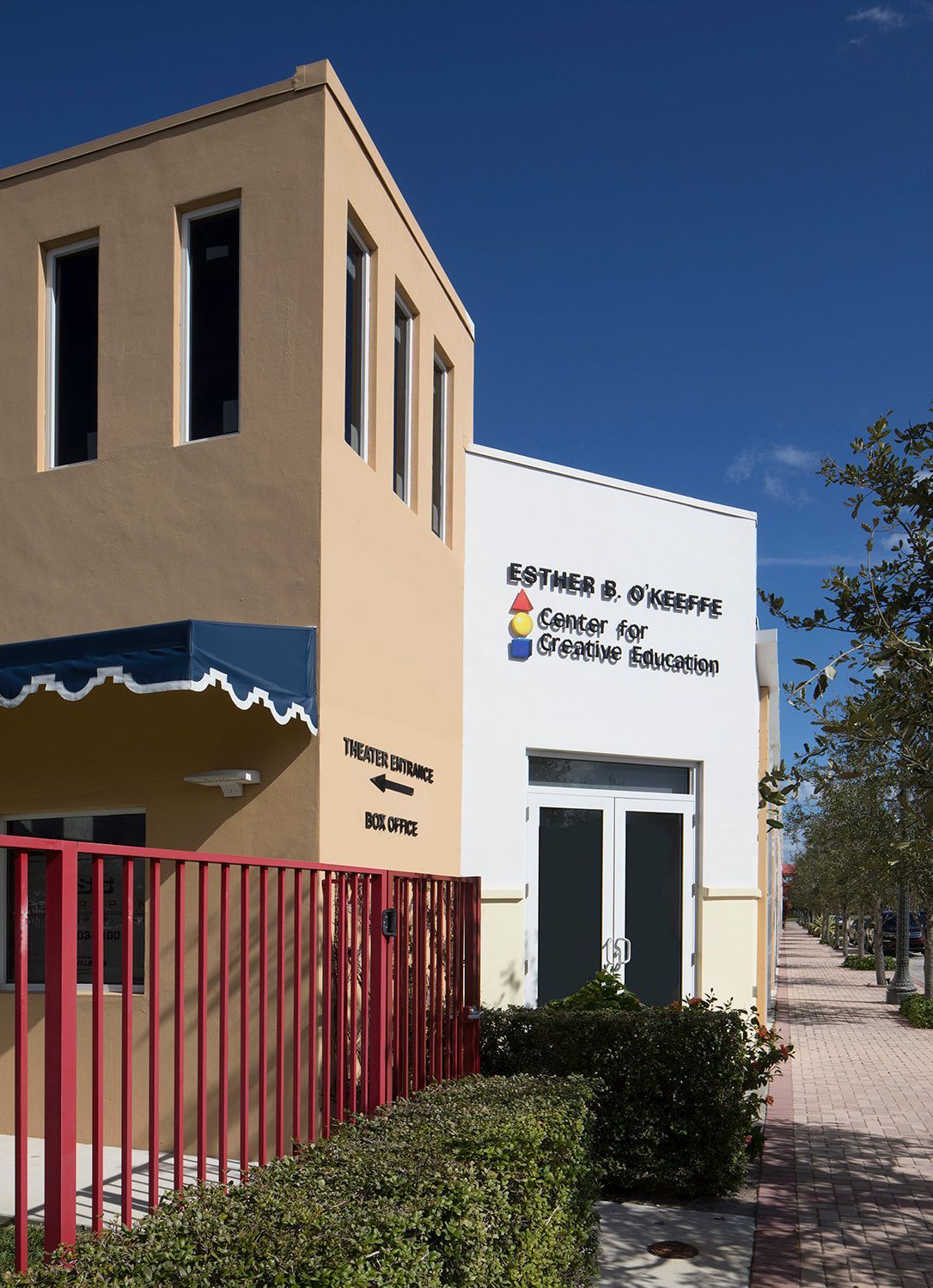 A building with a red fence and a blue awning