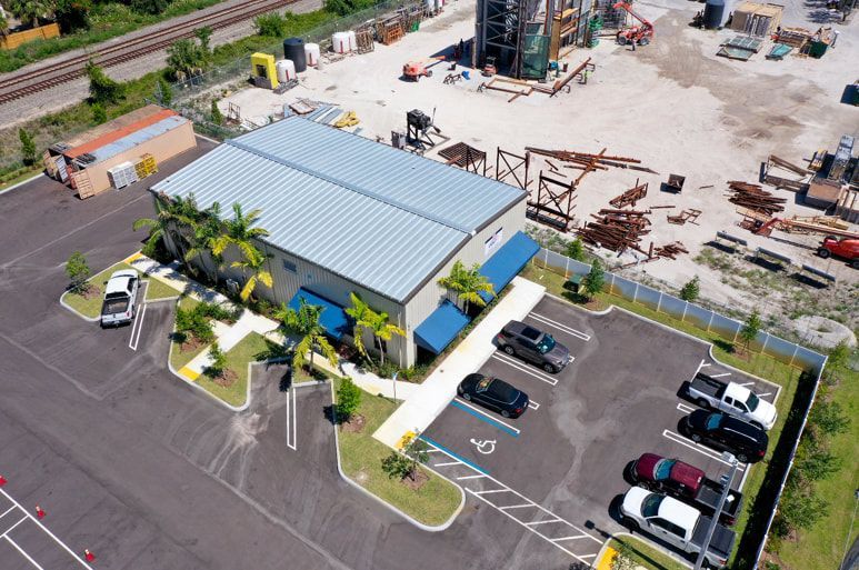 An aerial view of a building with a parking lot in front of it.