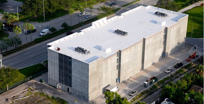 An aerial view of a large building with a white roof