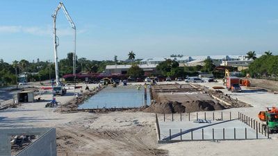 A large construction site with a concrete pump in the middle of it.