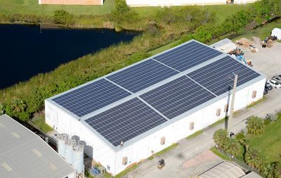 An aerial view of a building with solar panels on the roof.