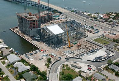 An aerial view of a building under construction next to a body of water