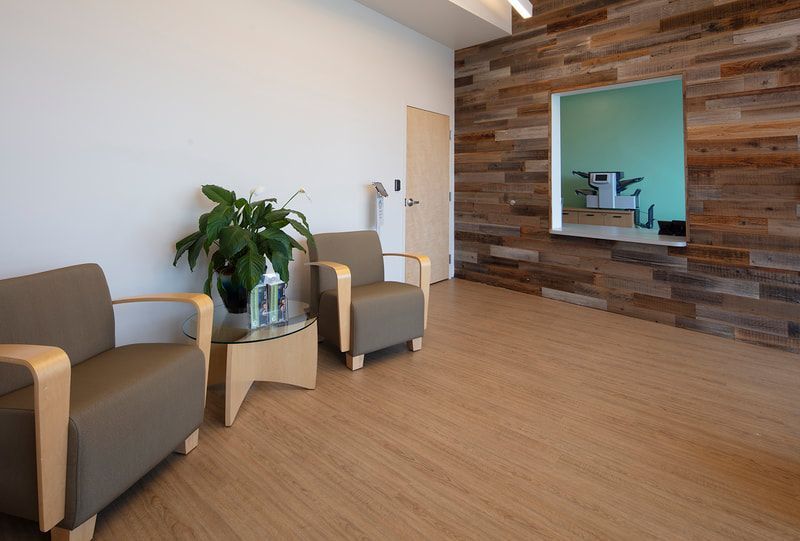 There are two chairs and a table in the waiting room.