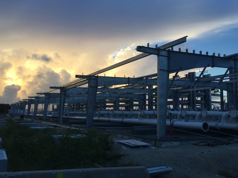 A building under construction with a sunset in the background
