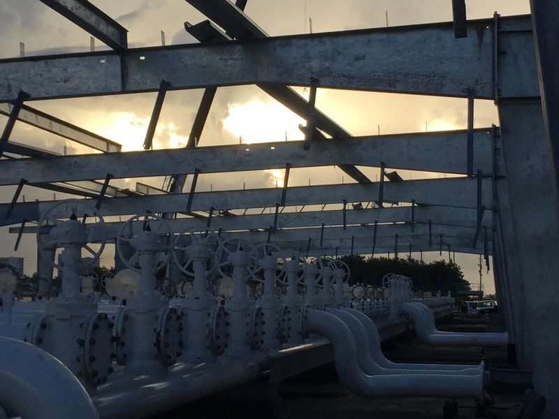 A row of pipes are lined up under a metal structure