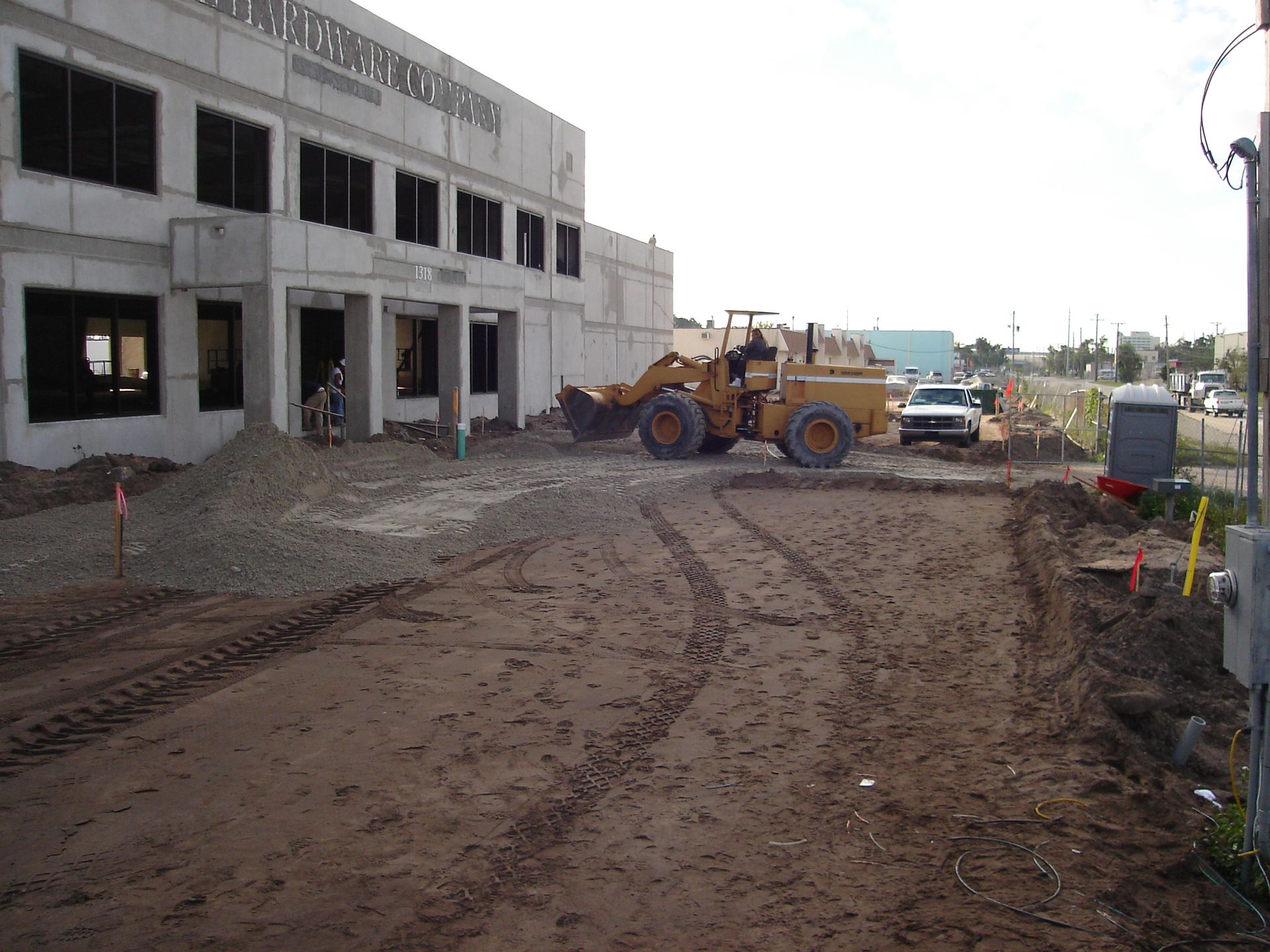 A bulldozer is moving dirt in front of a building that is under construction