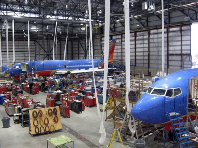 A blue southwest airplane is being built in a hangar