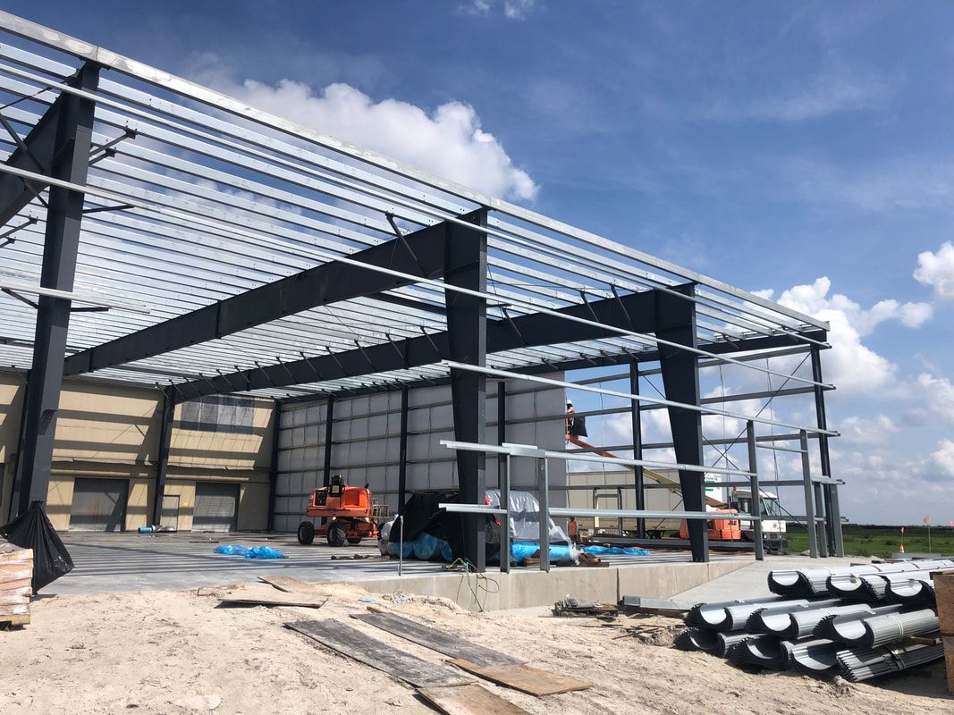 A large metal structure is being built on a construction site.