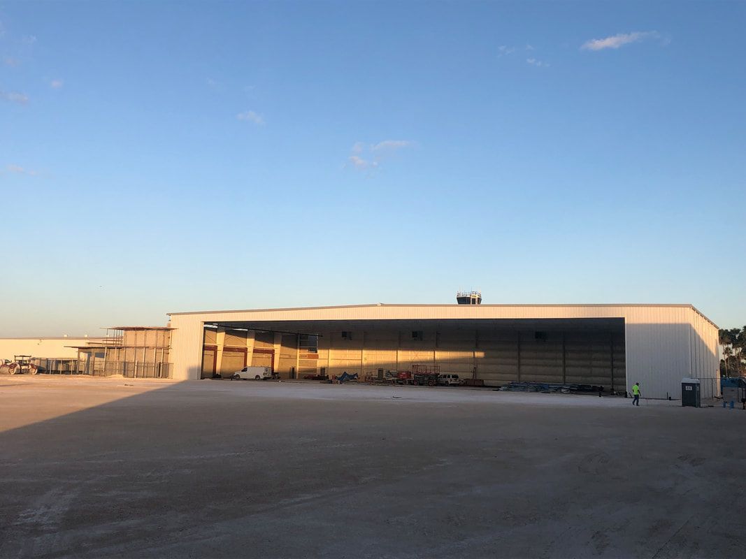 A large white building with a lot of cars parked in front of it.