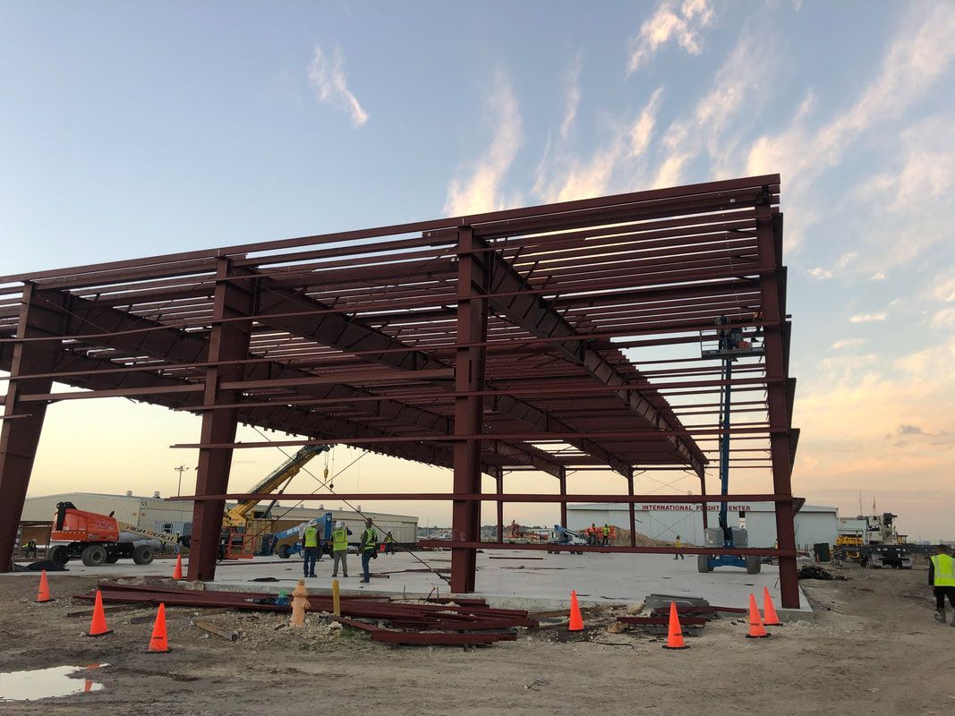 A large metal structure is being built on a construction site.