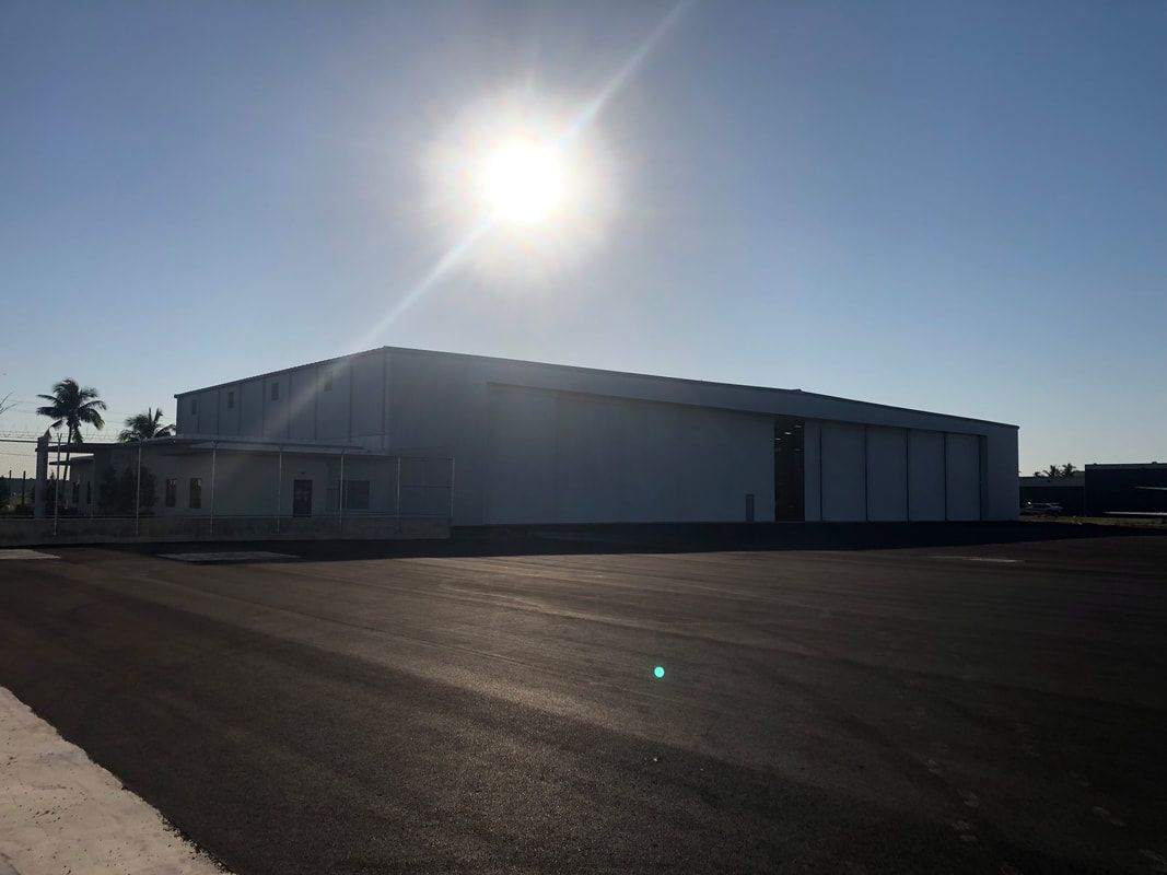 A large white building with the sun shining on it.