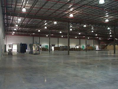 An empty warehouse with a lot of lights on the ceiling