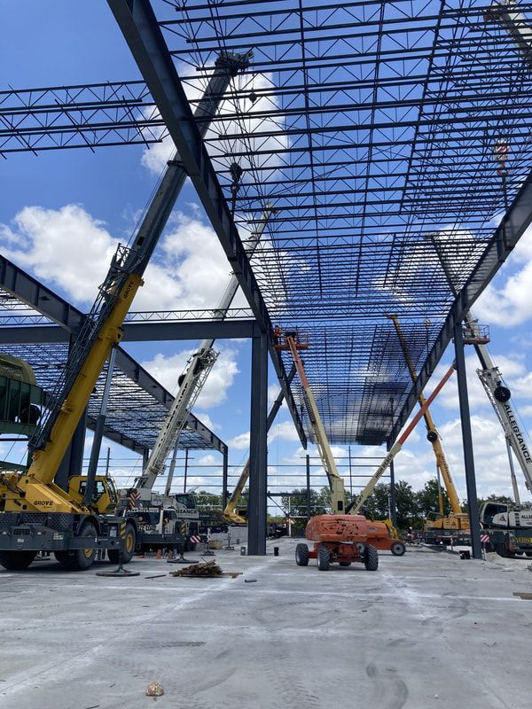 A construction site with a lot of cranes and trucks.
